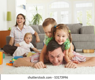 Happy Family Having Fun On Floor Of In Living Room At Home, Laughing.