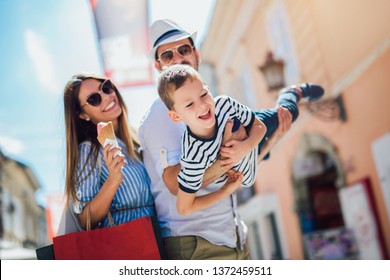Fröhliche Familie, die sich nach dem Einkaufen im Freien amüsiert