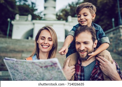 Happy Family Is Having Fun Outdoors. Father, Mother And Son Are Spending Time Together While Exploring New City.