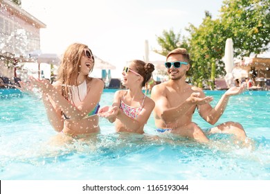 Happy Family Having Fun In Pool On Sunny Day