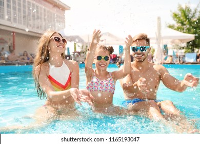 Happy Family Having Fun In Pool On Sunny Day