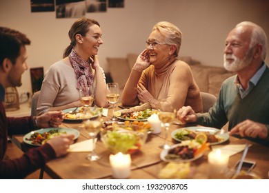 Happy Family Having Fun And Talking While Having Dinner At Dining Table. Focus Is On Senior Woman. 