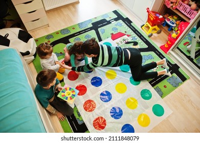 Happy Family Having Fun Together,four Kids Playing Twister Game At Home.