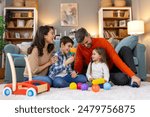 Happy family having fun with toys, parents and little children sit on sofa together, Happy family sitting on sofa playing together. Cheerful parents playing with their kids at home.