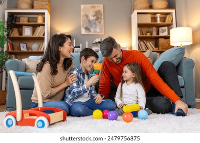 Happy family having fun with toys, parents and little children sit on sofa together, Happy family sitting on sofa playing together. Cheerful parents playing with their kids at home. - Powered by Shutterstock