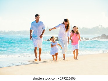 Happy Family Having Fun Walking On The Beach