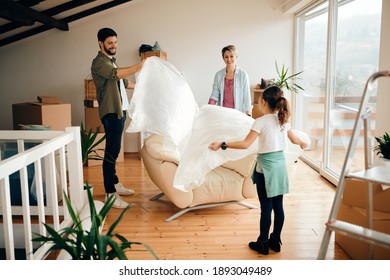 Happy Family Having Fun While Unpacking Furniture At Their New House. 