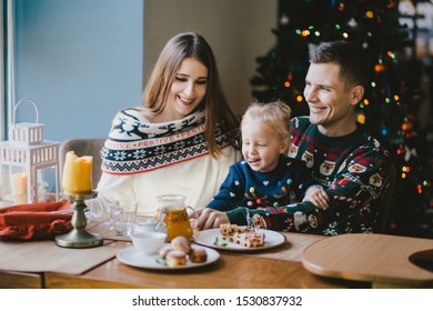 Happy Family Having Holiday Breakfast On Christmas Morning.