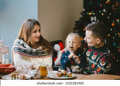 Happy Family Having Holiday Breakfast On Christmas Morning.