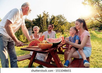 Happy Family Having Lunch At Summer Garden Party.People,food,love And Happiness Concept.