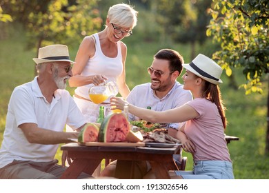 Happy Family Having Lunch At Summer Garden Party. People, Food, Love And Happiness Concept.