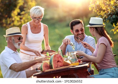 Fröhliche Familie zu Mittag auf der Gartenparty im Sommer. Menschen, Essen, Liebe und Glück Konzept.