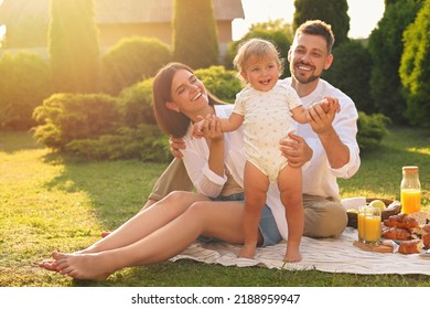 Happy family having picnic in garden on sunny day