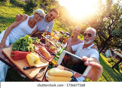 Happy family having picnic in the park on a sunny day, enjoying together and take selfie. - Powered by Shutterstock