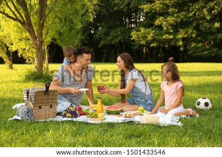 Happy family having picnic in park on sunny summer day