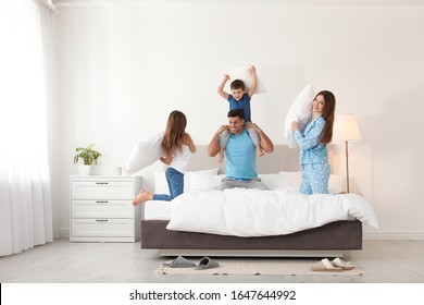 Happy Family Having Pillow Fight In Bedroom