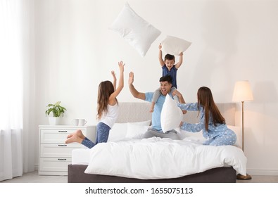 Happy Family Having Pillow Fight In Bedroom