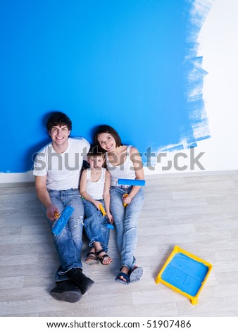 Happy family having a rest after painting the wall - high angle