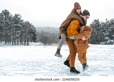 Happy family having a walk in winter outdoors in snow - Powered by Shutterstock