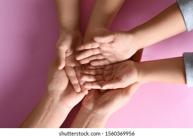 Happy family holding hands on pink background, top view - Shutterstock ID 1560369956