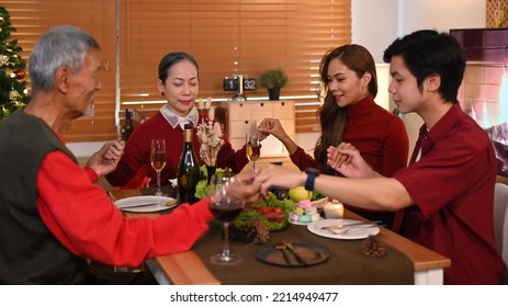 Happy Family Holding Hands And Praying Before Christmas Meal. Christmas, New Year, Thanksgiving And Celebration Concept