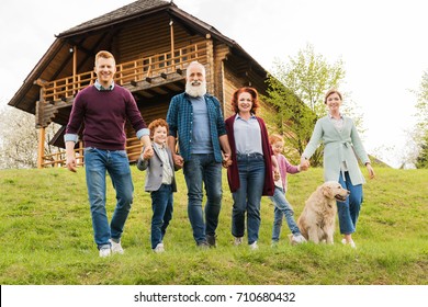 happy family holding hands together while running near country house in village - Powered by Shutterstock