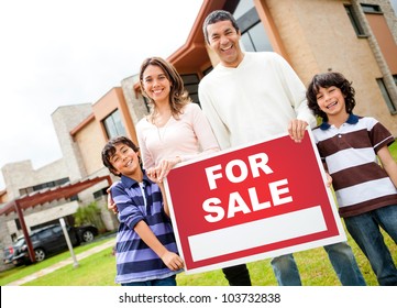 Happy Family Holding Poster Of A House For Sale