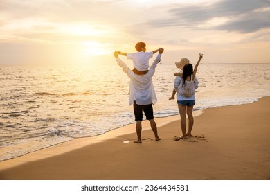 Happy family in holiday. Father, Mother and kids having fun together shoulder ride on summer beach, Parents carrying children on shoulders at beach on sunset time, Family on holiday summer vacation - Powered by Shutterstock