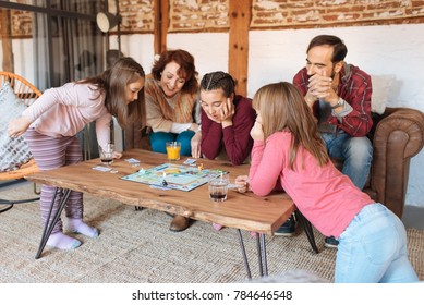 Happy family at home in the couch playing classic table games 