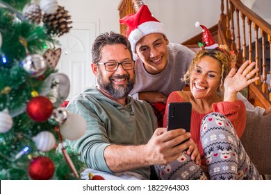 Happy Family At Home During Christmas Eve Day Enjoy A Video Phone Call With Friends And Parents - Concept Of Happy People And Online Internet Technology - People Modern Lifestyle Having Fun Together