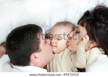 Similar – Mother reading book to her sons in the bed