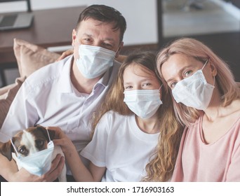 Happy Family At Home. Mom Dad And Child On Sofa During The Pandemic Coronavirus Quarantine