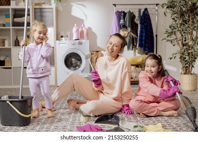 Happy Family At Home. Mother And Daughters Clean The House. Young Woman And Children Vacuum Sweep Mop Floor And Cleaners. Cute Little Helpers.