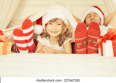 Happy Family At Home. Mother, Father And Child With Christmas Gift. Winter Holiday Concept