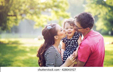 Happy Family Hugging In A Park