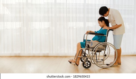 
Happy family : Husband and wife take care of health, pregnant wife ride in a wheelchair for antenatal care, childbirth, see an obstetrician and gynecologist in the hospital : Copy space
