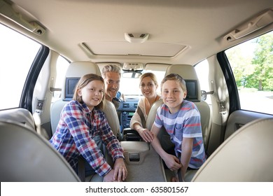 Happy Family Inside Car Leaving For Vacation