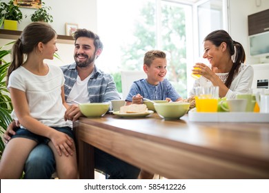 Happy family interacting while having breakfast