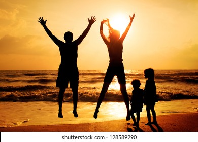 Happy family jumping on the beach on the dawn time - Shutterstock ID 128589290
