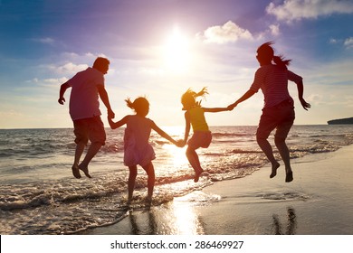 happy family jumping together on the beach