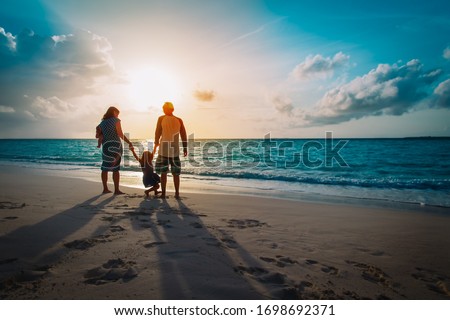 happy family with kids play on sunset beach