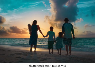 Happy Family With Kids Walk At Sunset Beach