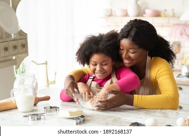 Happy Family In Kitchen. Black Mother And Little Daughter Preparing Dough Together, Loving African American Mom Teaching Her Child Cooking And Baking Homemade Pastry, Enjoying Spending Time With Kid