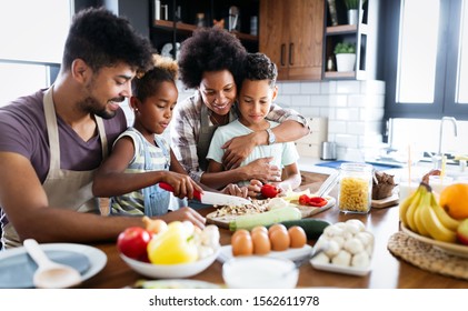 Happy family in the kitchen having fun and cooking together. Healthy food at home. - Shutterstock ID 1562611978