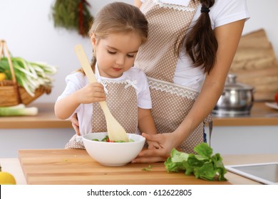 Happy Family In The Kitchen. Mother And Child Daughter  Cooking Tasty Breakfast Of Fresh Salad