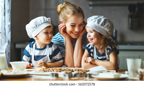 happy family in the kitchen. mother and  children preparing the dough, bake cookies