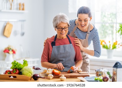 Happy family in the kitchen. Mother and her adult daughter are preparing proper meal.  - Powered by Shutterstock