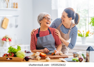 Happy family in the kitchen. Mother and her adult daughter are preparing proper meal.  - Powered by Shutterstock