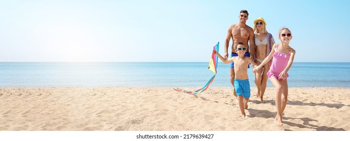 Happy family with kite at beach on sunny day, space for text. Banner design - Powered by Shutterstock