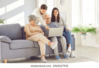 Happy family laptop using online, aging parents and adult children, old and youth together at home. Elderly mother, father, grandmother, grandfather kind affection, trust, family peace, generation  - Powered by Shutterstock